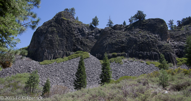 "The Columns of the Giants were created by perfect conditions, when lava flowed into an ancient riverbed and pooled behind a natural dam. As this deep pool of lava slowly cooled, the molten rock hardened and shrank, splitting into multi-sided vertical columns. As the hot lava cooled, like most liquids, it shrank, causing tension in the new rock. Cracking relieved the vertical stress. Vertical columns occurred only where lava of uniform composition and thickness cooled evenly from top to bottom. During the first lava flow the straight columns were formed. The second flow left twisted upper layers over the already cooled first layer. The vanished glacier during the ice age polished the tops of these columns, leaving behind their scrape marks and exposing the columns. The rocks at the base of the columns are called talus. As water seeped into cracks in the rock and froze, the expanding ice crystals slowly wedged the massive blocks apart. Heaps of smaller rocks collected at the bottom where they’ve separated and fallen. You can feel the cool air rising through the talus. Remnants of this ancient ice still remain, covered and preserved by the fallen rock." Tuolumne County Historical Society